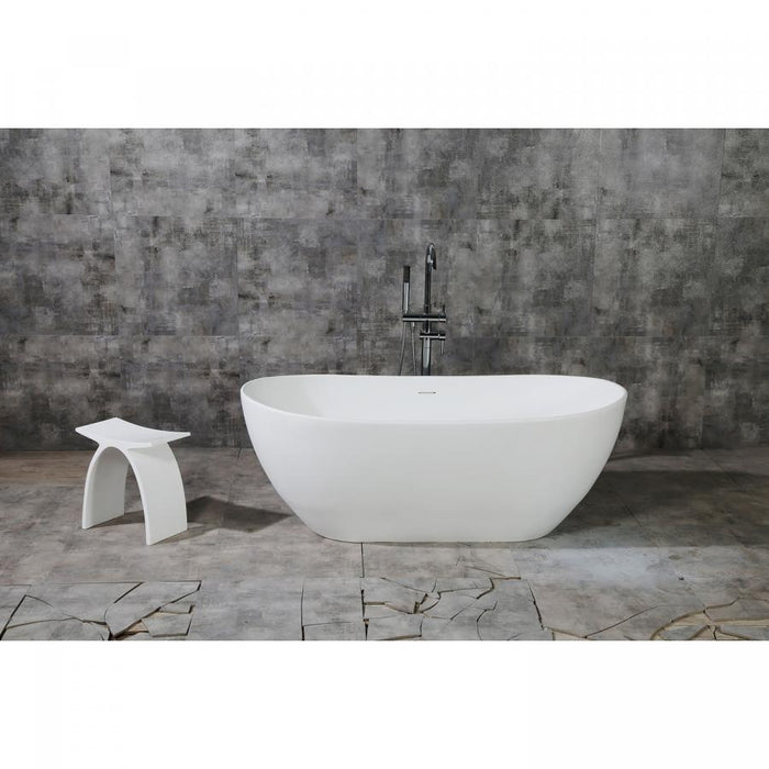 Matte white solid surface stone freestanding tub in a calm, softly lit modern bathroom