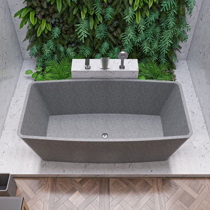 Solid concrete rectangular freestanding soaking tub in gray matte, set in a calm, minimal bathroom